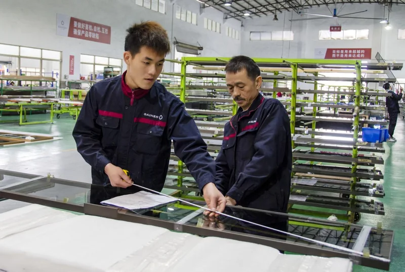 Gainer workers checking the dimensions and fitting of a glass door