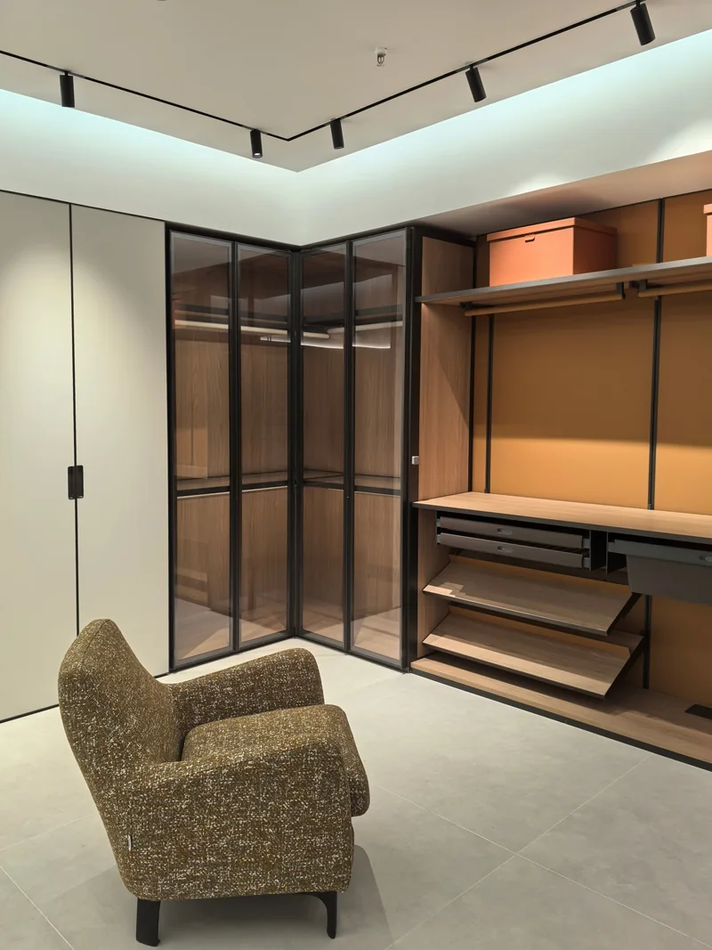 Glass wardrobe doors beside open shelves and hanging rails in a past Gainer wardrobe project